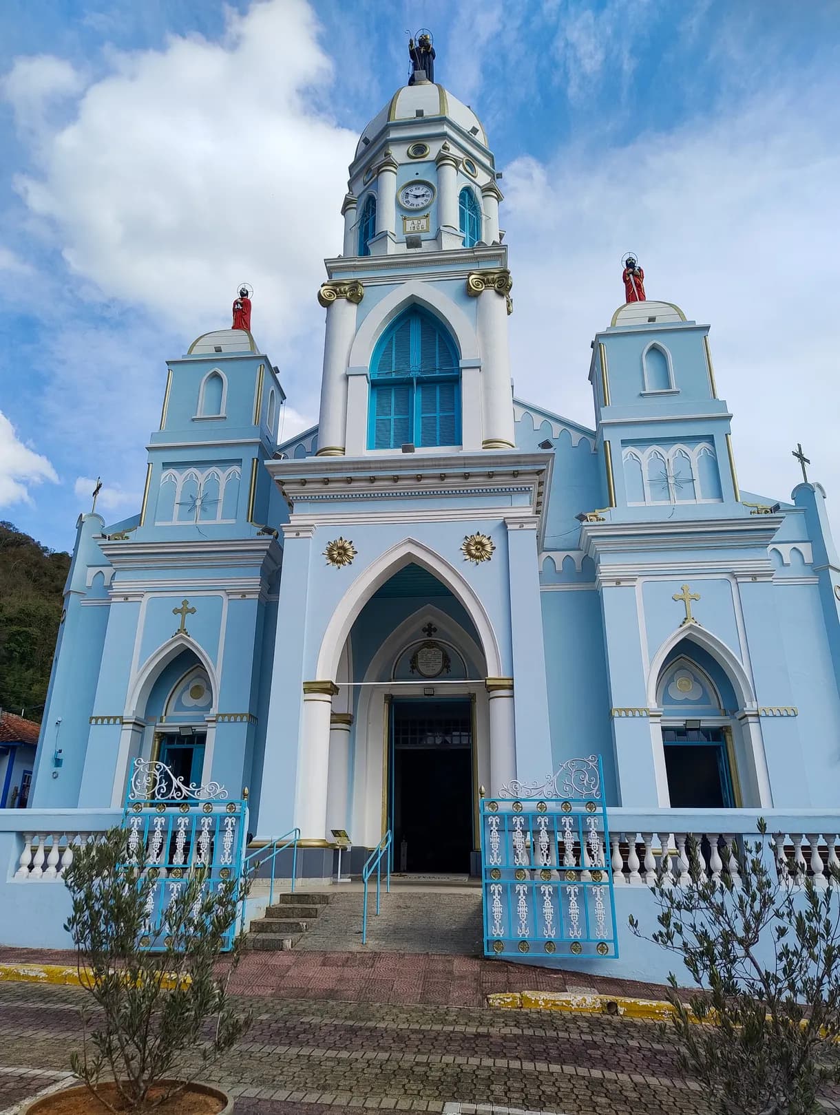 Nave da Igreja Matriz em direção ao altar, com bancos de madeira, piso de losangos e forro azul-claro