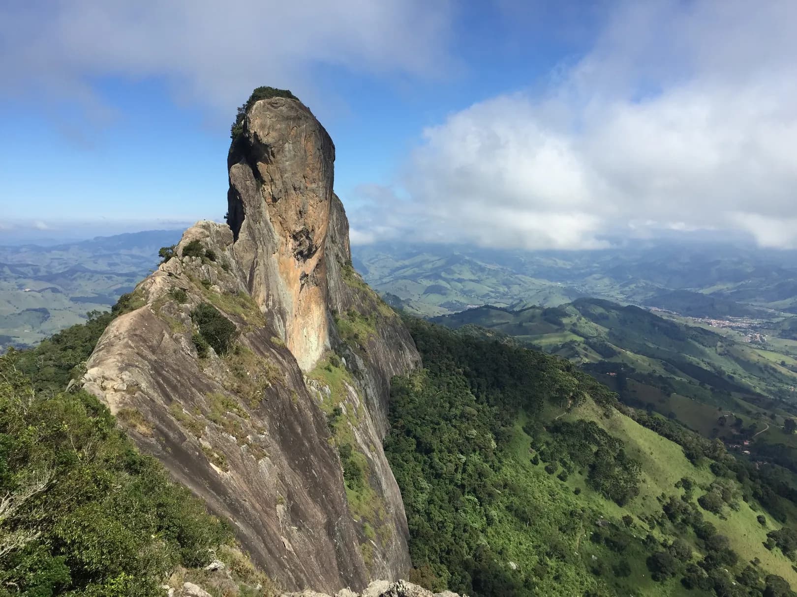 Pedra do Baú vista do alto da Pedra do Bauzinho, com a encosta de mata e o casario de São Bento do Sapucaí no vale