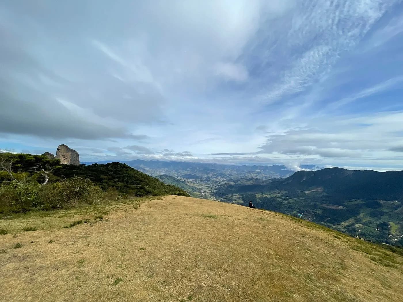 Topo da rampa com um paredão de rocha à esquerda e o vale aberto sob nuvens altas