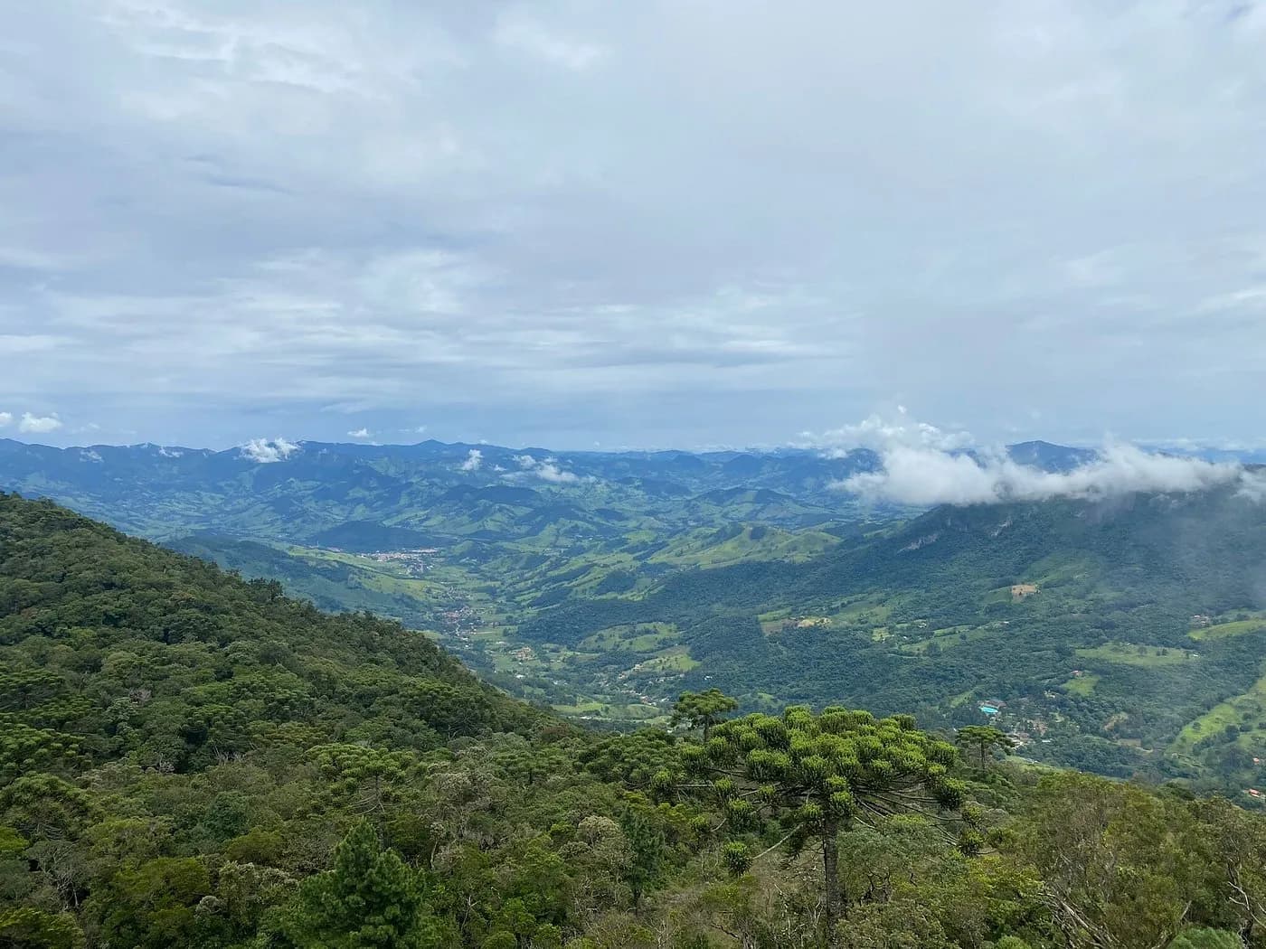 Mar de montanhas visto do alto da rampa, com nuvens baixas presas nas encostas